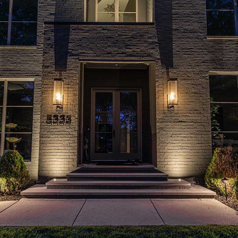 Recessed up lights in concrete flanking entrance